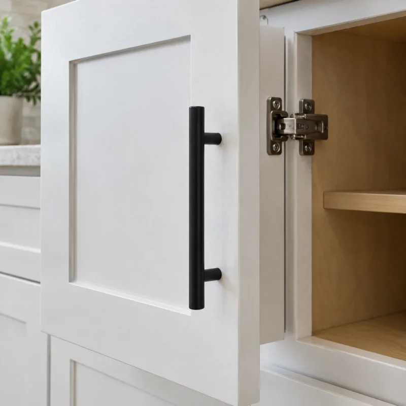Close-up of a new white painted shaker door hung on an existing cabinet box, with a soft-close hinge and a new matte black pull